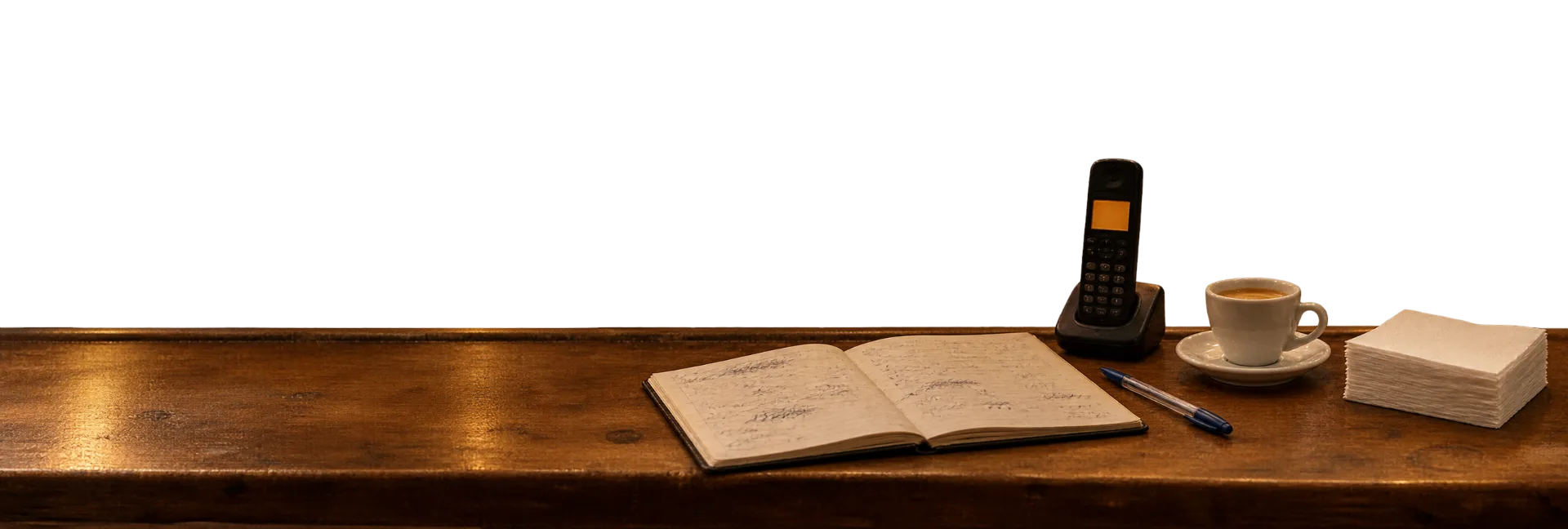Barra del restaurante con un teléfono inalámbrico iluminado y una libreta de reservas llena de tachones.
